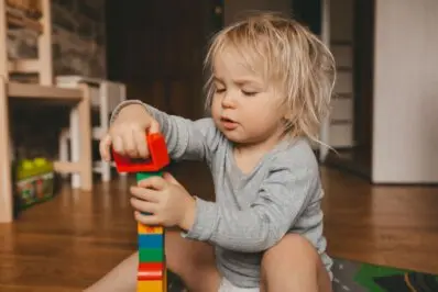 Bright home day care playroom with shelves of toys and a cozy reading corner